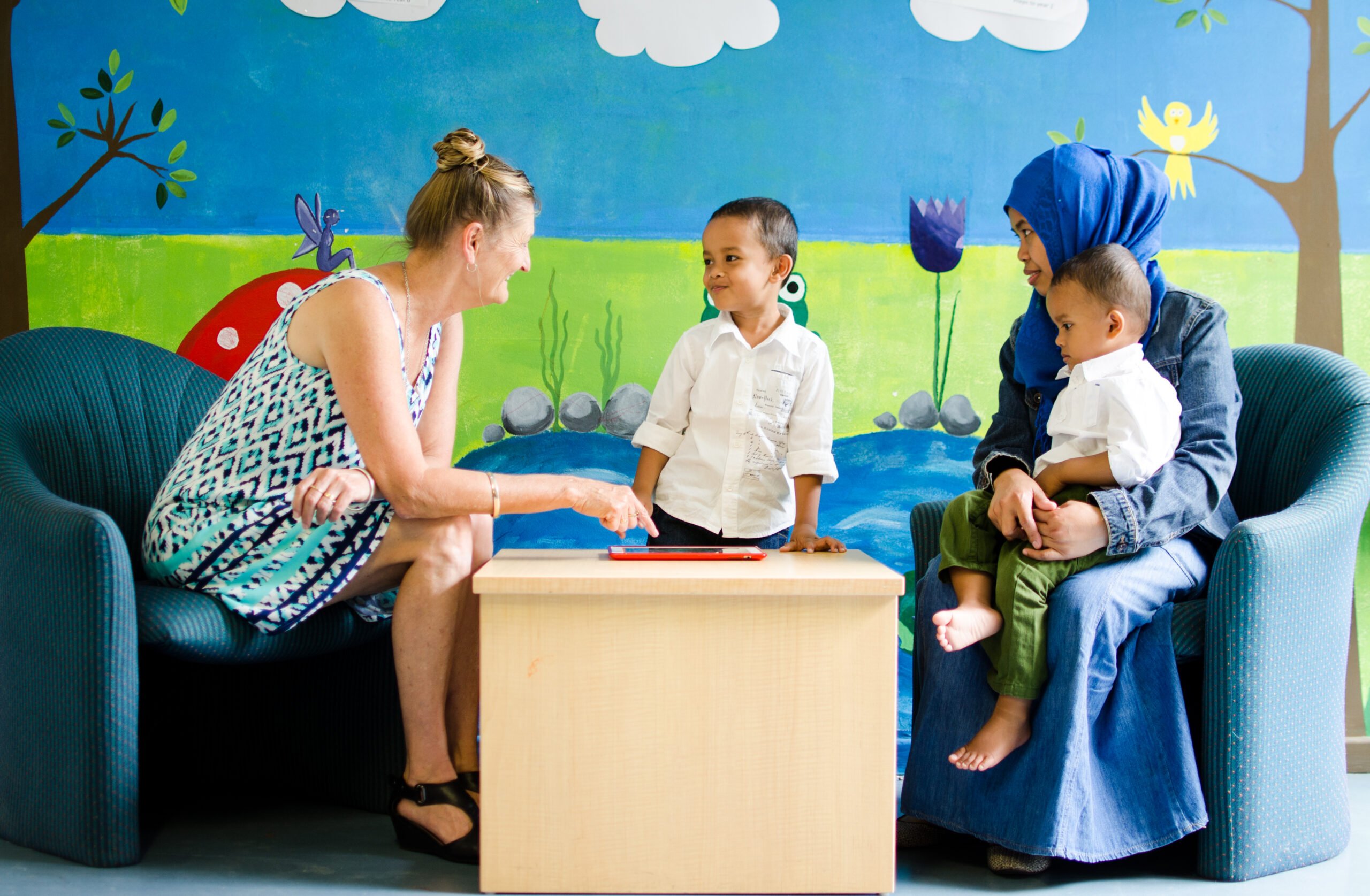 Care worker talking to mother with 2 sons