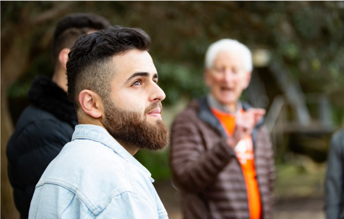 Young man gazing at the sky in a group setting at Welcome Program outing