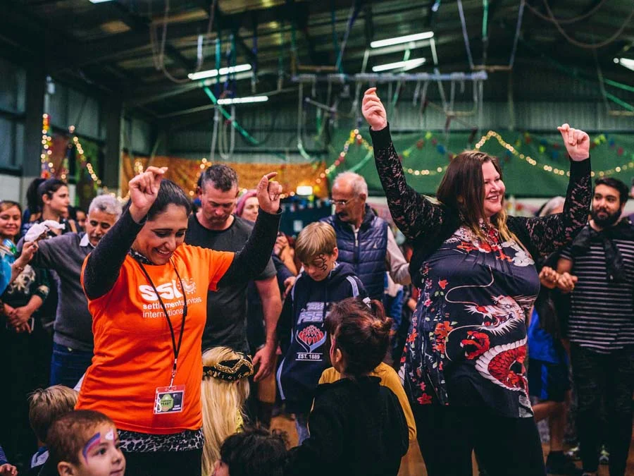SSI volunteers and newcomers dancing together