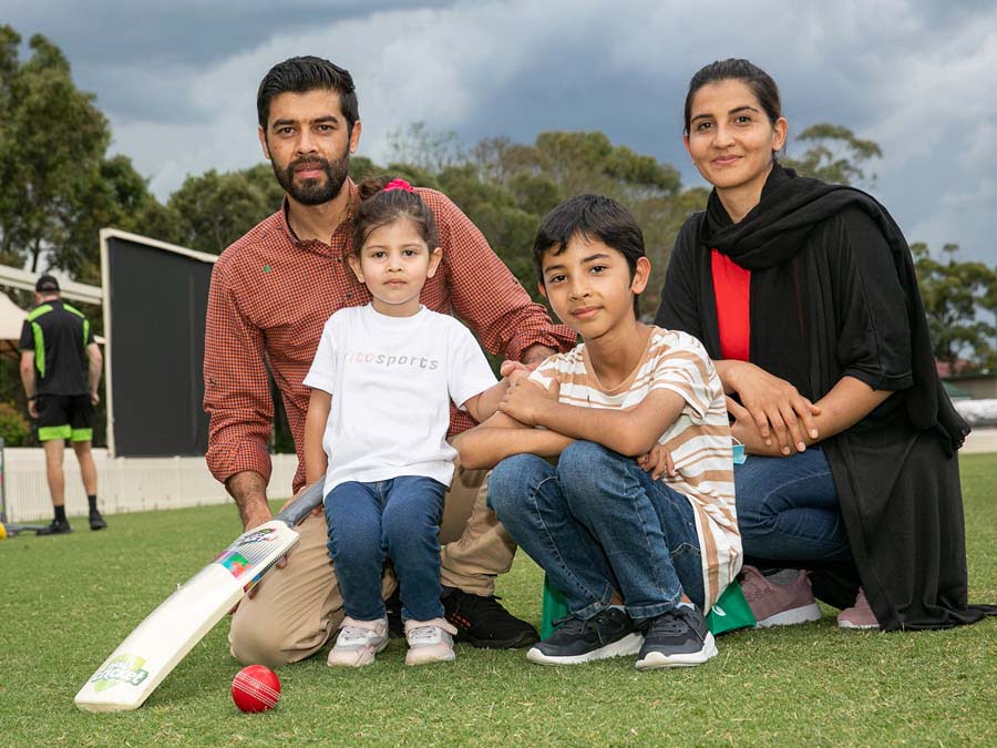 Family posing together on a cricket pitch
