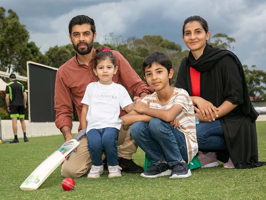 Family posing together on a cricket pitch