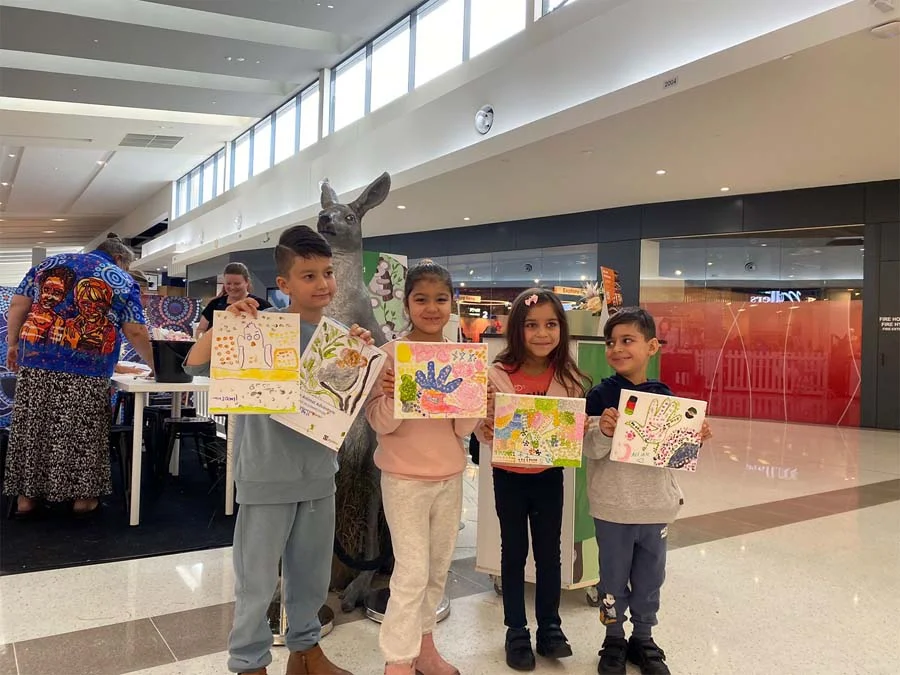 Children proudly showing the art they created