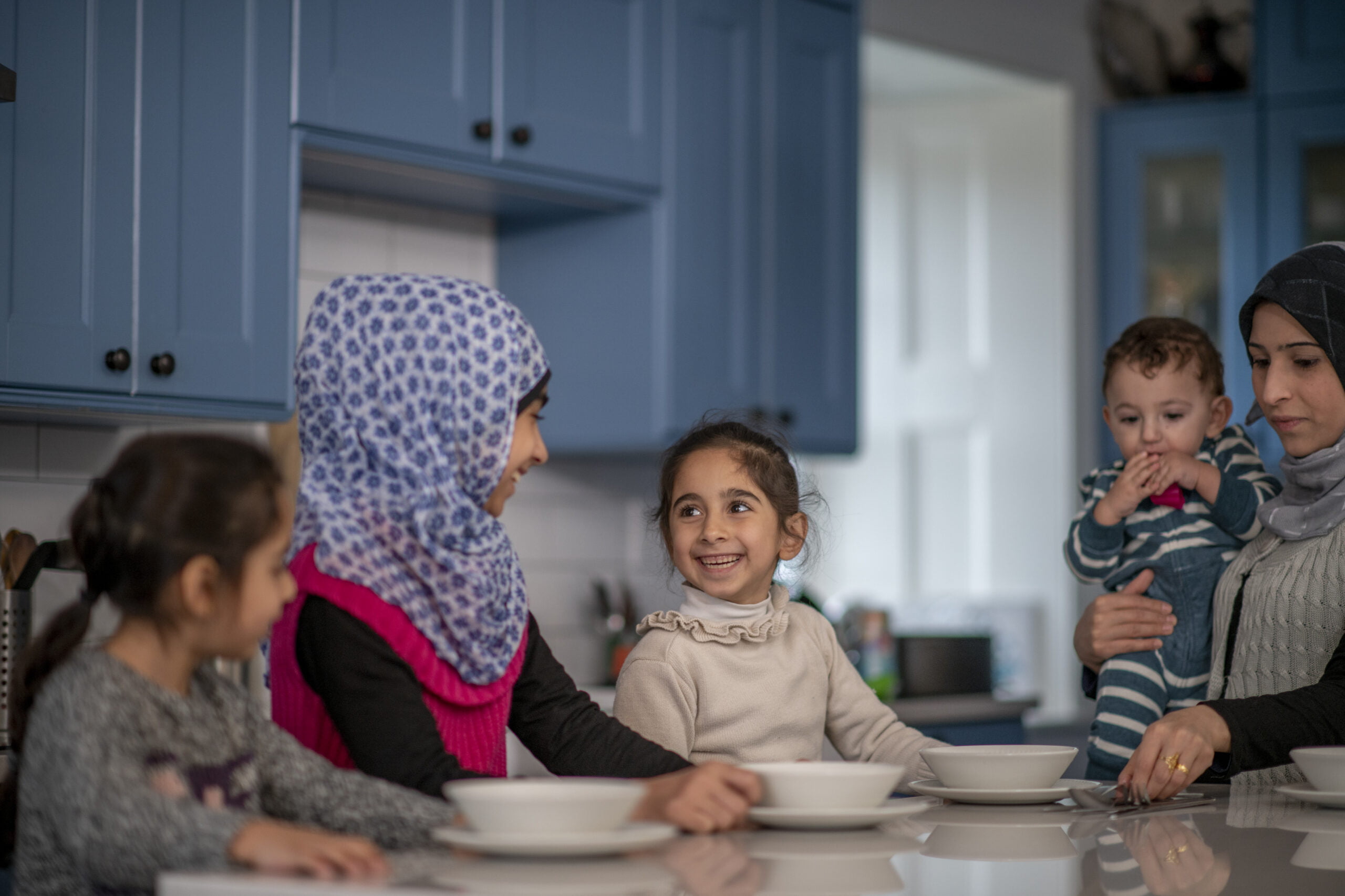 Family of refugees sitting at table for meal in regional NSW