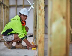 Female participant from CALD community works on a construction site in South Western Sydney using a measuring tape