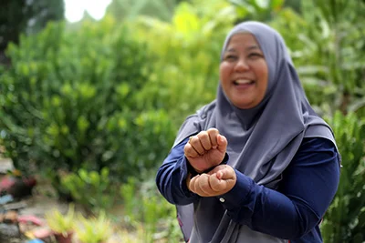Young woman outdoors using sign language