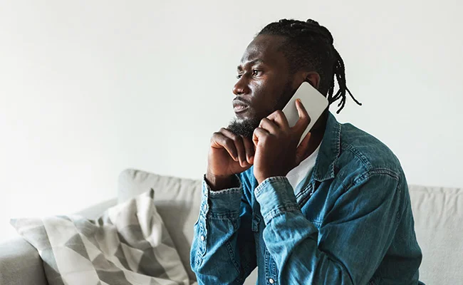 Somali man on the phone on the couch