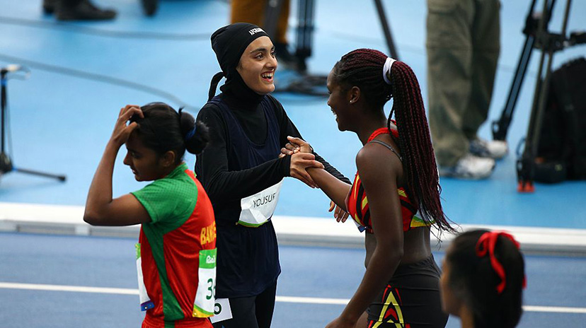 Kimia taking part in athletics event and congratulating opponent.