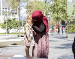 Young muslim mother comforting her little daughter, background with copy space