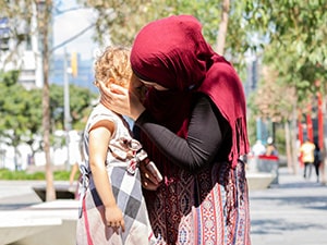 Young muslim mother comforting her little daughter, background with copy space