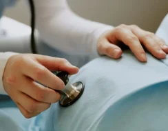 Midwifes supporting women experiencing domestic violence with stethoscope on tummy