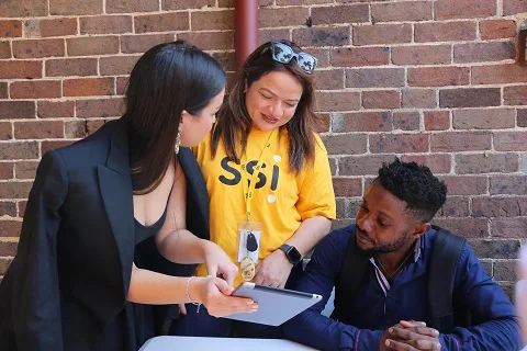 3 SSI staff members looking at digital tablet
