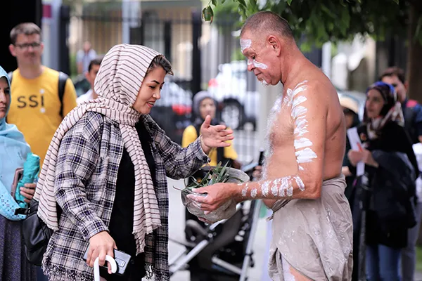 First Nations man and woman in headscarf at traditional smoking ceremony.