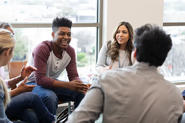 A group of young people are sat talking in an office space