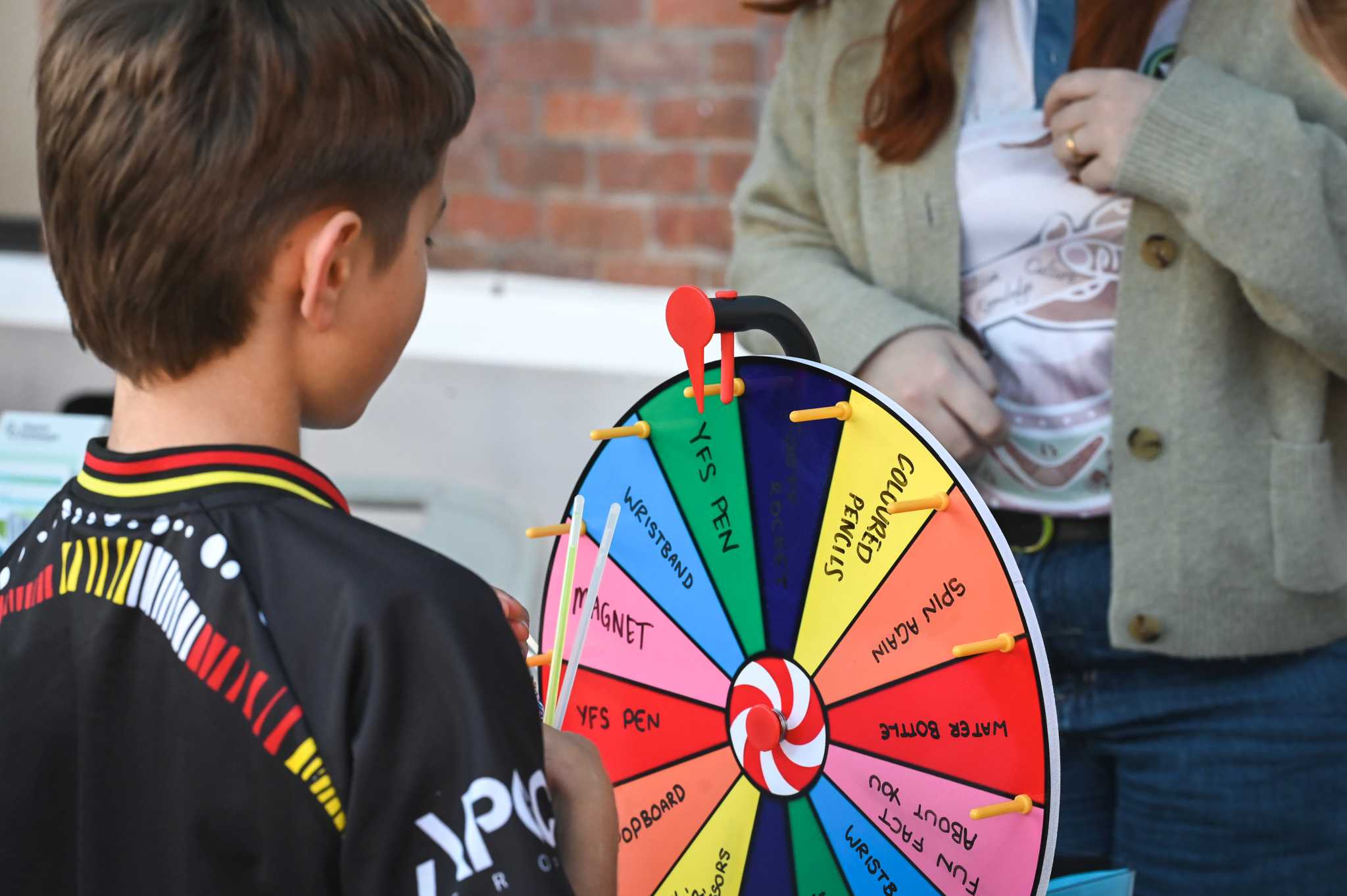 A boy spins a wheel for a prize at World of Cultures