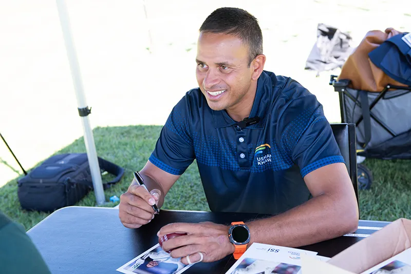 Usman Khawaja signing autographs and smiling